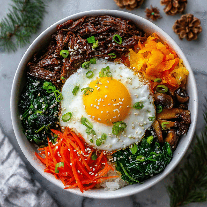 Delicious quick Korean Bibimbap with marinated beef, colorful vegetables, and a fried egg for a cozy and satisfying meal.