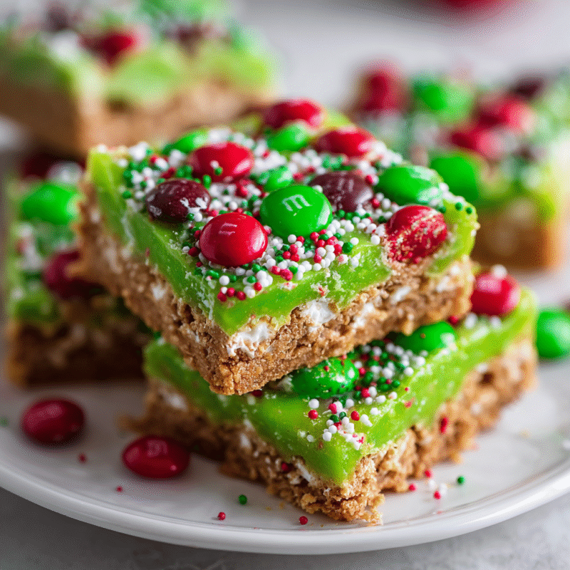 No-bake Grinch Christmas Crack with vibrant green candy melts, graham crackers, and M&Ms for festive holiday fun.