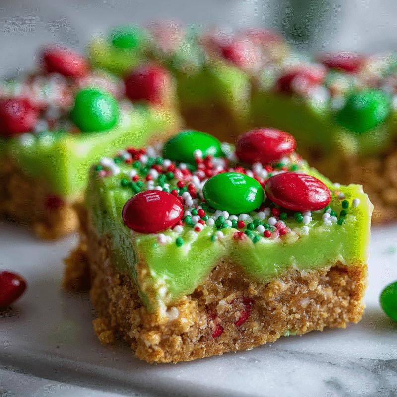 No-bake Grinch Christmas Crack with vibrant green candy melts, graham crackers, and M&Ms for festive holiday fun.