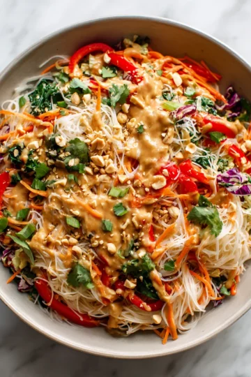 Thai Noodle Salad with Peanut Sauce topped with fresh ingredients, vibrant and colorful dish perfect for gatherings and holiday tables.