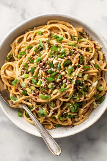 Delicious spicy peanut butter noodles ready in 10 minutes, perfect for quick meals with customizable ingredients.