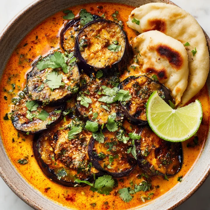 Grilled aubergine curry showcasing smoky and vibrant flavors, perfect for cozy dinners and gatherings.