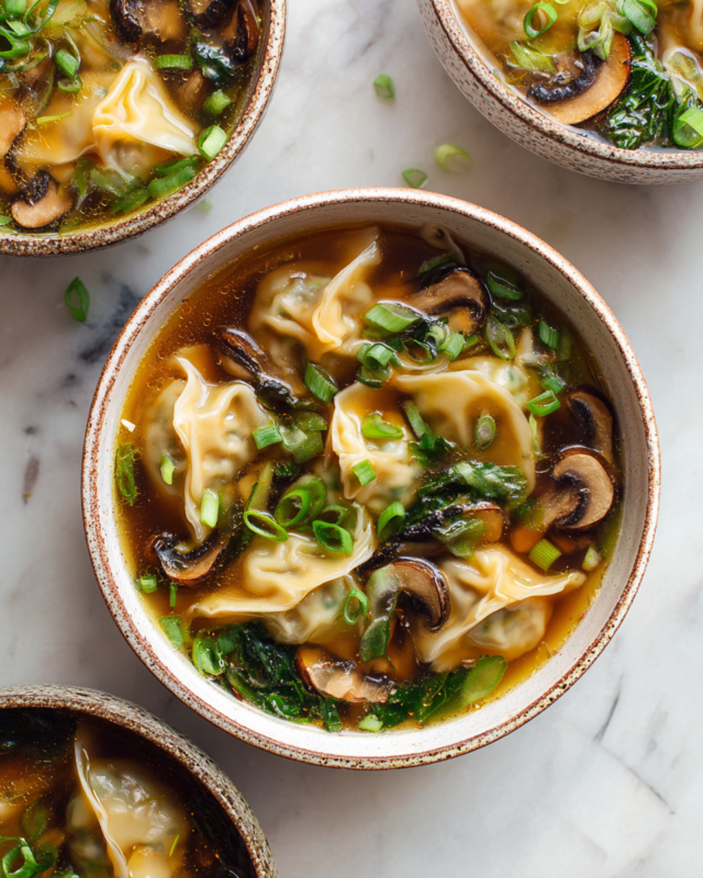 Bowl of Gyoza Soup with dumplings, bok choy, and shiitake mushrooms in chicken broth