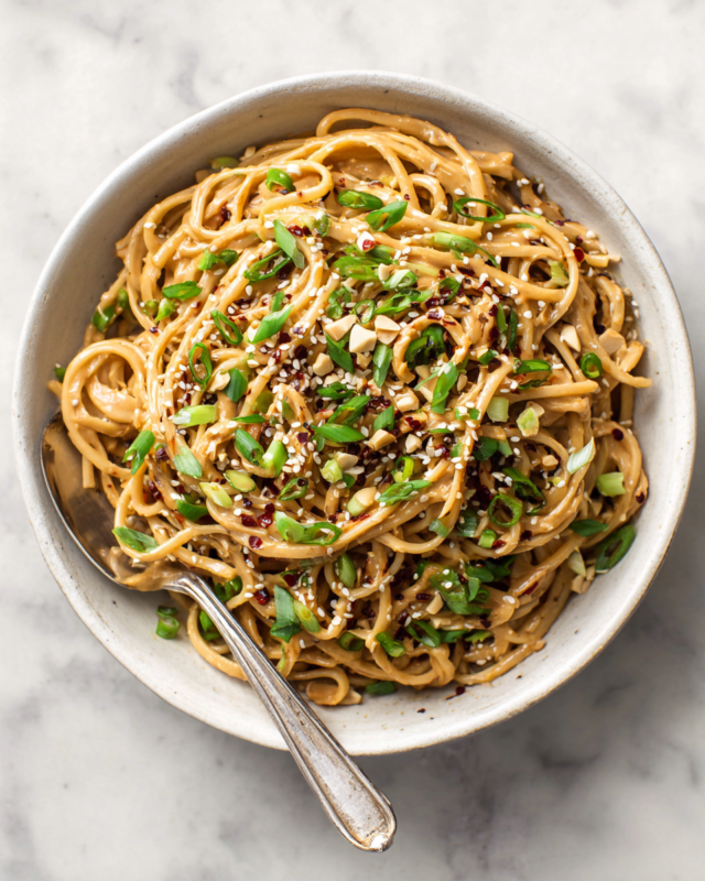 Delicious spicy peanut butter noodles ready in 10 minutes, perfect for quick meals with customizable ingredients.